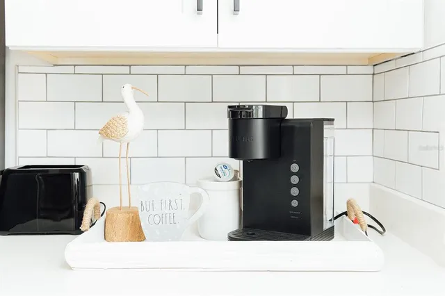 a bedroom with a white bed and a painting on the wall