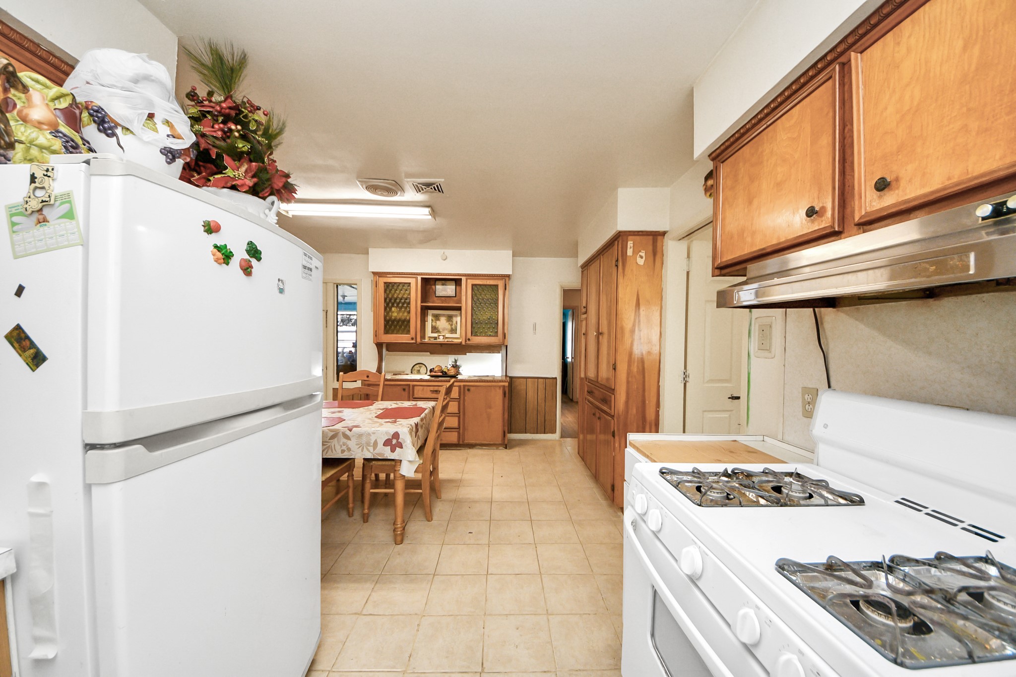 9701 Foredale Street Houston, TX 77075 - Photo 11 of 32 a kitchen with a refrigerator a stove and a dining table