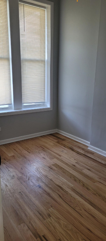 1227 South Springfield Avenue, Unit 1 Chicago, IL 60623 - Photo 5 of 6 an empty room with wooden floor and windows