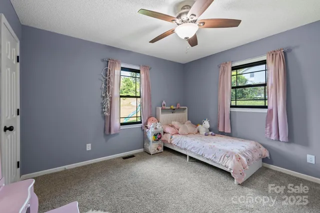 a bedroom with a bed chandelier and a window