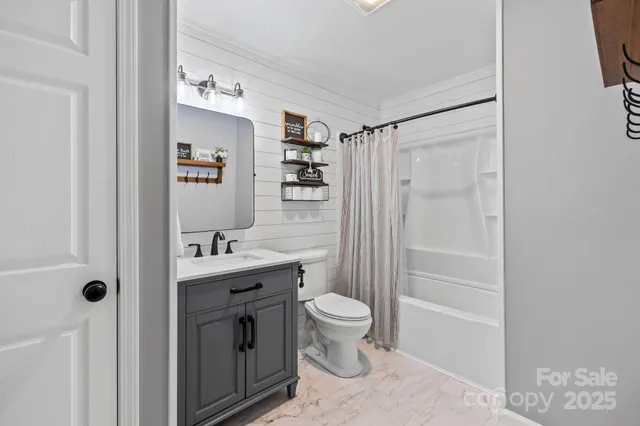 a bathroom with a sink a toilet a mirror and shower