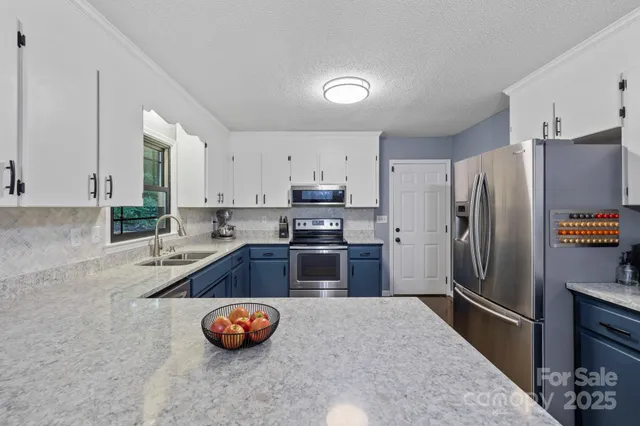 a kitchen with granite countertop a refrigerator and a sink