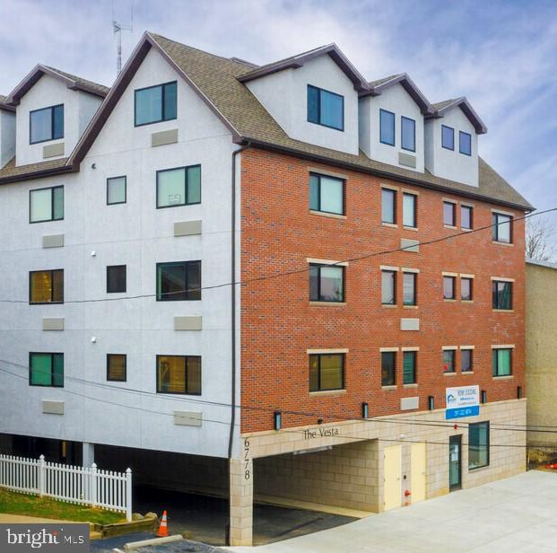 6778 Ridge Avenue, Unit 306 Philadelphia, PA 19128 - Photo 6 of 6 a front view of a building with glass windows and a ceiling fan