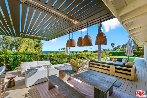 a view of patio with a table and chairs under an umbrella