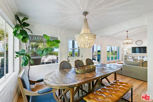a view of a dining room with furniture a chandelier and wooden floor