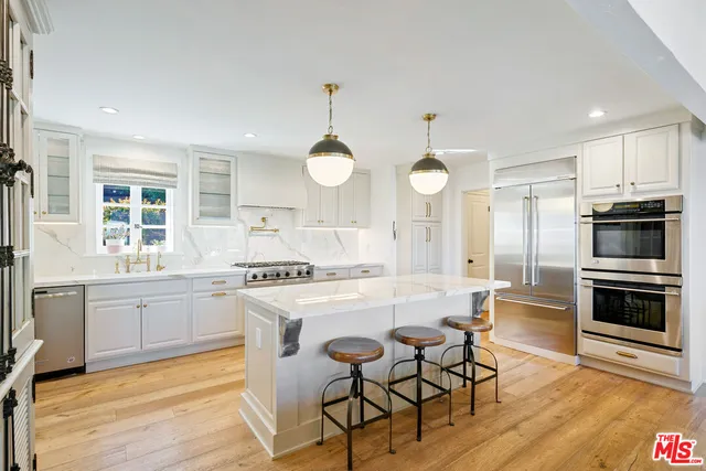 a large kitchen with kitchen island a large island in the center and stainless steel appliances