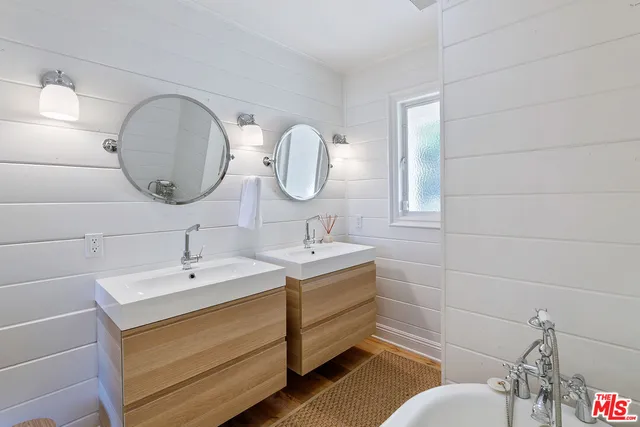 a bathroom with a double vanity sink mirror and toilet