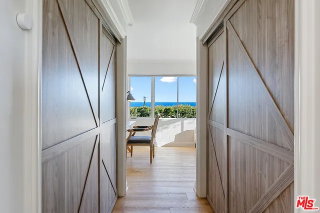 a view of a hallway with wooden floor and staircase