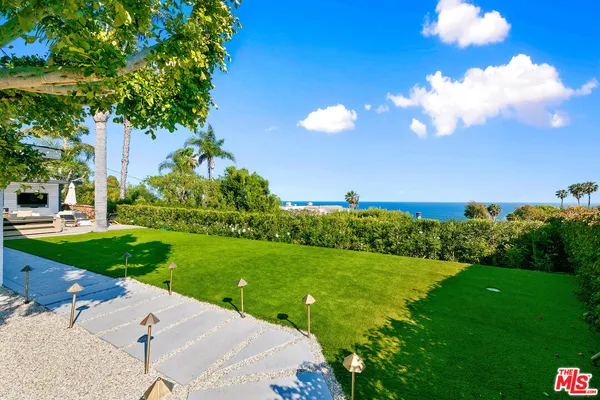 a view of a garden with a house in the background