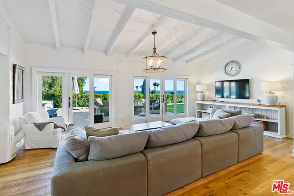 a living room with furniture flat screen tv and a large window