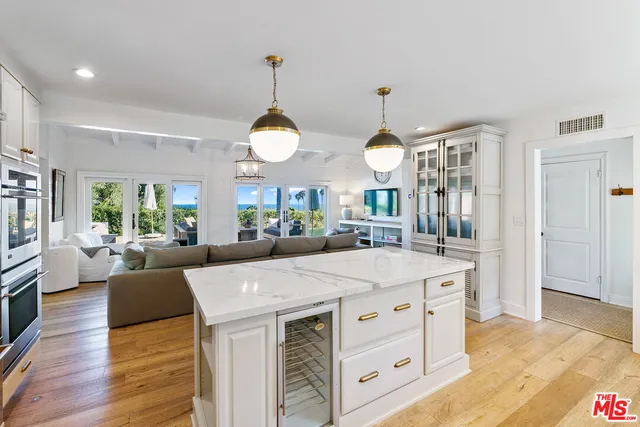 a large white kitchen with a large island oven a stove and a refrigerator