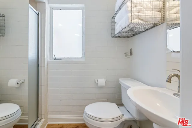 a front view of a house with a yard and potted plants