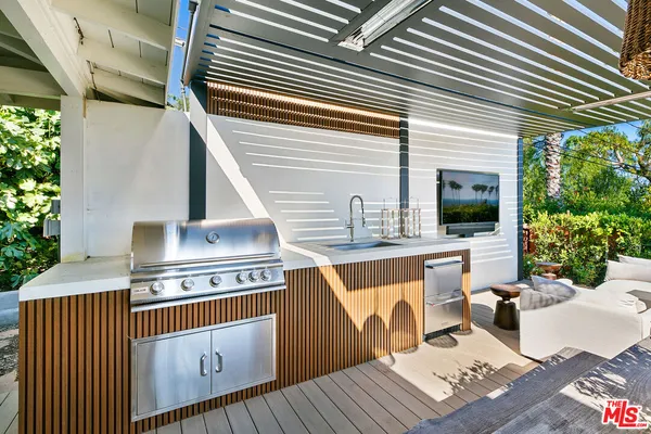 a view of a patio with table and chairs with wooden floor and fence