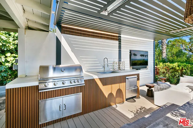 a view of a patio with table and chairs with wooden floor and fence