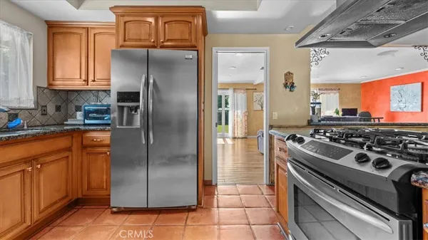 a kitchen with stainless steel appliances granite countertop a stove refrigerator and cabinets