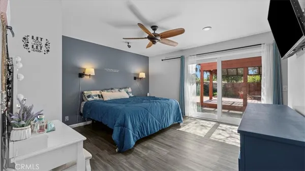 a bedroom with a large bed a chandelier and dresser