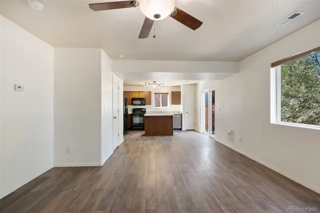 a living room with stainless steel appliances wooden floors and view living room