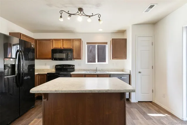 a kitchen with a sink a counter top space stainless steel appliances and cabinets