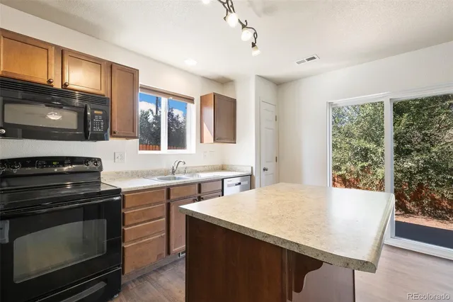 a kitchen with stainless steel appliances a stove sink microwave and cabinets