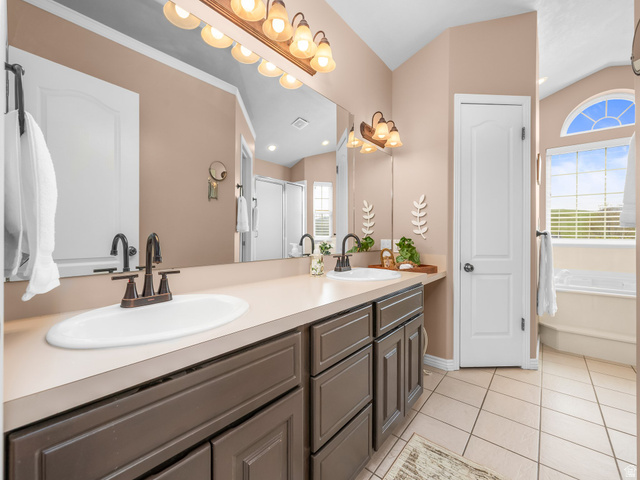 6849 North Black Powder Road Mountain Green, UT 84050 - Photo 15 of 43 Double vanity with integrated sinks and bronze-finish faucets set against a full-width mirror