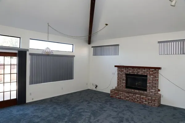 a living room with a fireplace and a ceiling fan