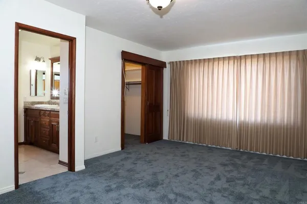 an empty room with windows and closet