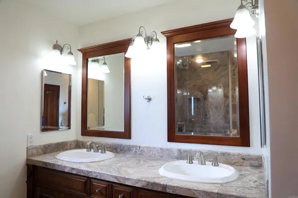 a bathroom with a granite countertop sink and a mirror