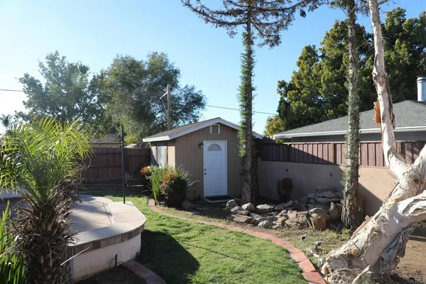 a view of backyard with seating space and trees