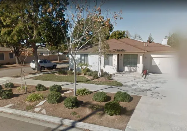 a view of a white house next to a yard