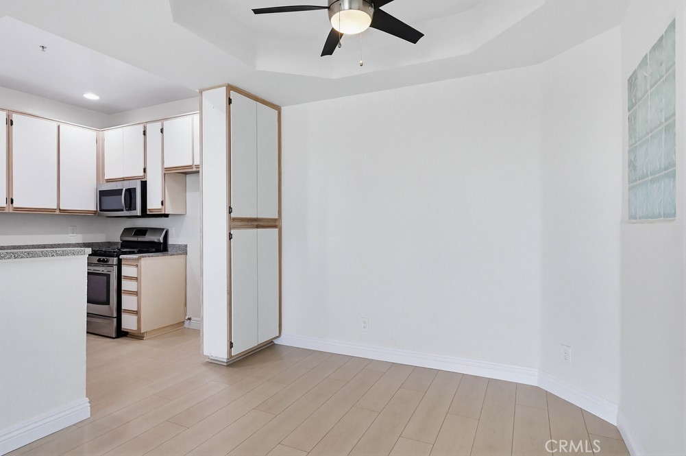 640 West 4th Street, Unit 401 Long Beach, CA 90802 - Photo 5 of 14 a view of a kitchen with white cabinets and stainless steel appliances