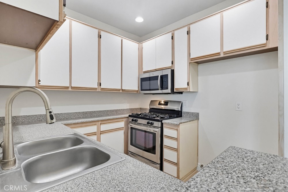 640 West 4th Street, Unit 401 Long Beach, CA 90802 - Photo 7 of 14 a kitchen with stainless steel appliances granite countertop a sink and a stove