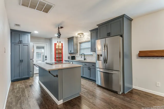 a kitchen with stainless steel appliances granite countertop a refrigerator and a stove top oven