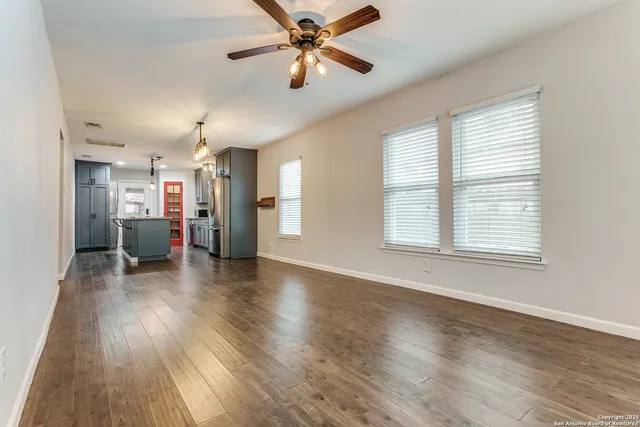 a view of a livingroom with a ceiling fan and window