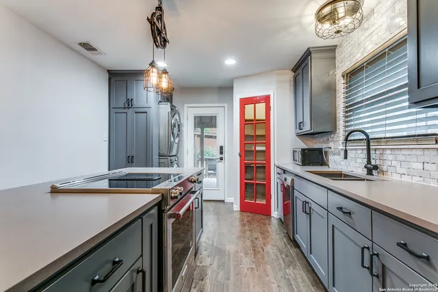 a kitchen with stainless steel appliances a sink stove and cabinets