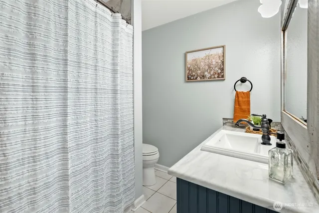 a bathroom with a sink a toilet and shower curtain