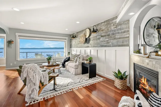 a living room with furniture a fireplace and a floor to ceiling window