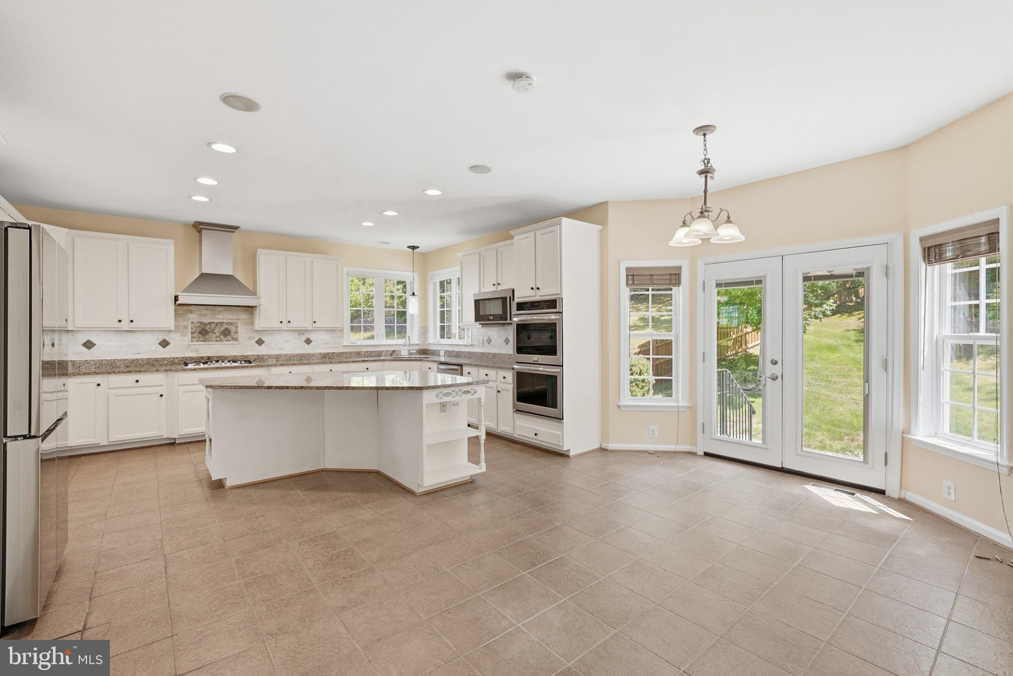 3679 Expedition Drive Triangle, VA 22172 - Photo 15 of 65 a large kitchen with cabinets a sink a window and stainless steel appliances