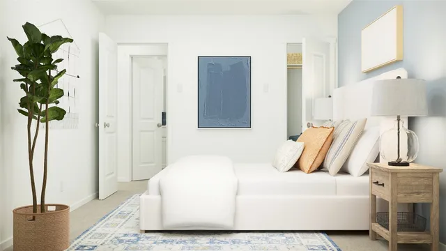 a bedroom with a bed and a potted plant