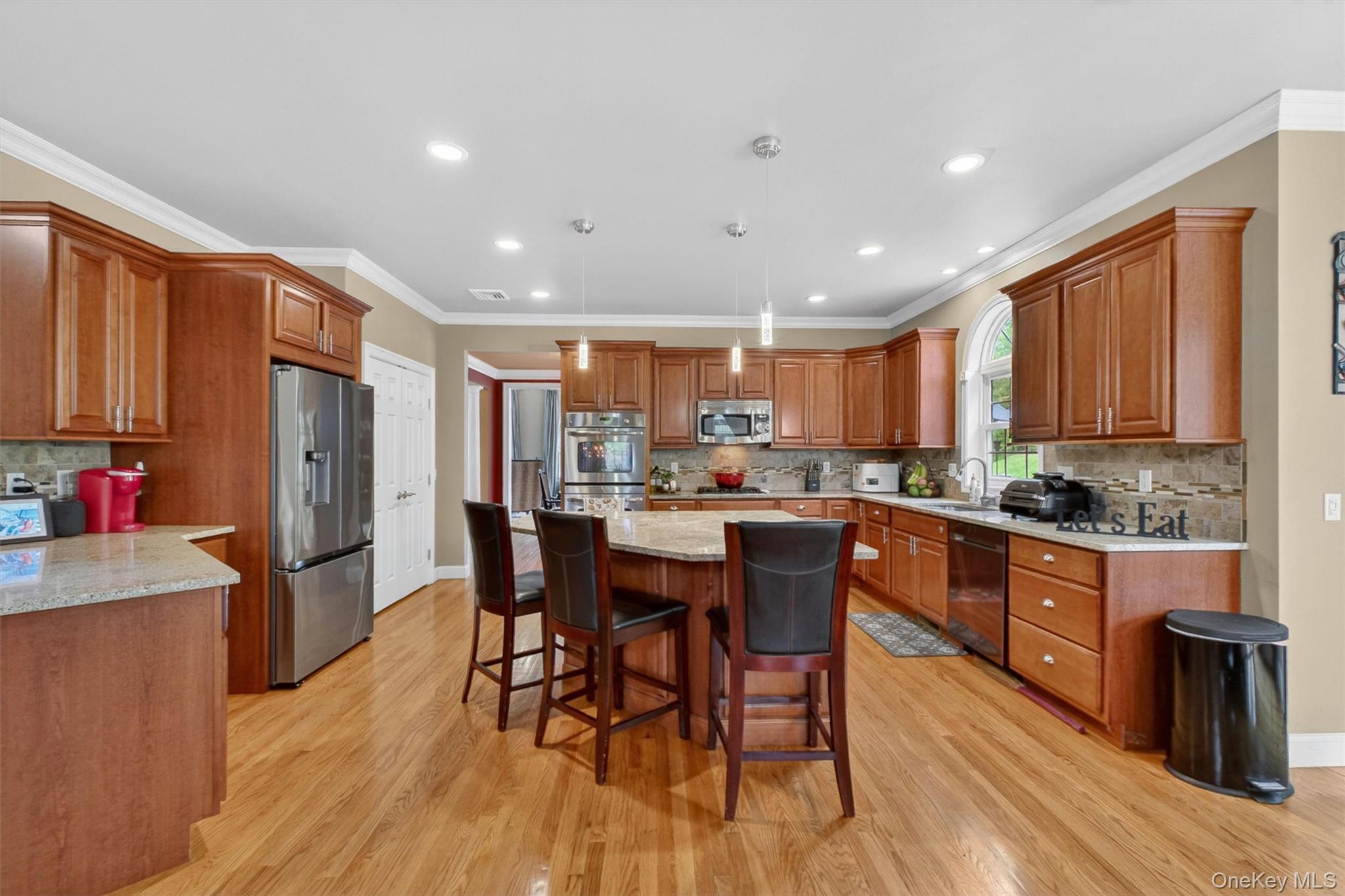 219 Country Club Road Hopewell Junction, NY 12533 - Photo 10 of 49 a kitchen with stainless steel appliances kitchen island granite countertop wooden floors and wooden cabinets