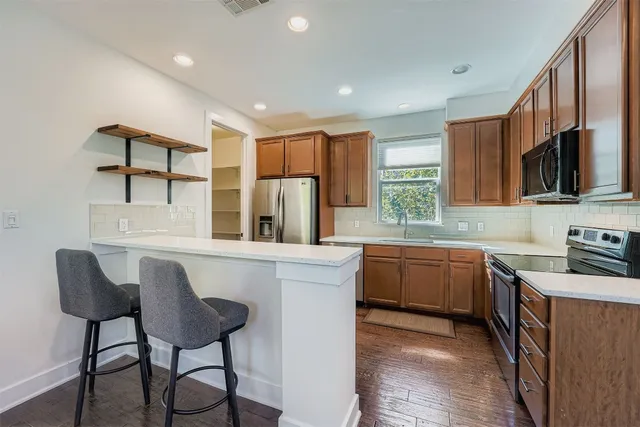 a kitchen with stainless steel appliances granite countertop white cabinets a stove top oven a sink and dishwasher