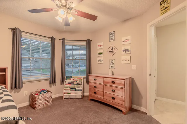 a bedroom with a bed and a chandelier fan