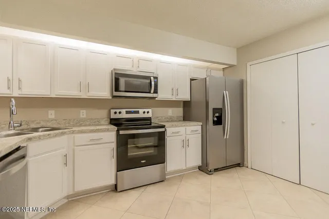 a kitchen with stainless steel appliances granite countertop a refrigerator and a stove top oven