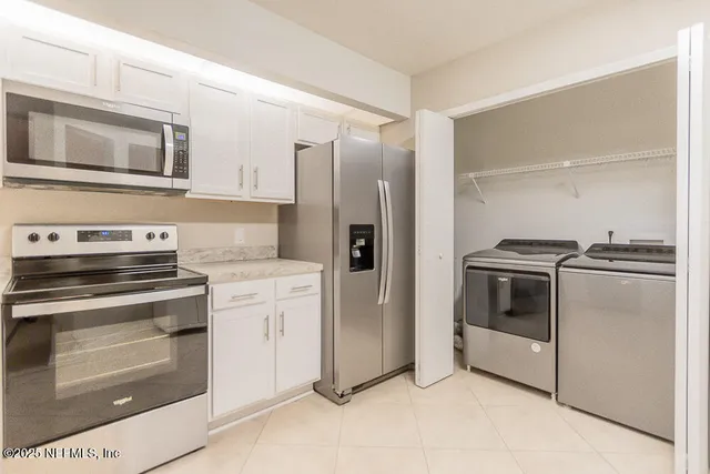 a kitchen with stainless steel appliances white cabinets and a stove top oven