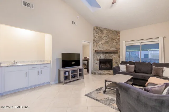 a living room with furniture a flat screen tv and a fireplace