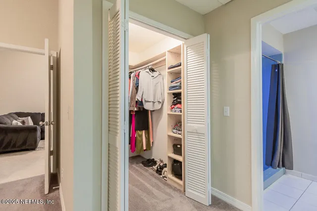 a view of walk in closet with clothes and shoes