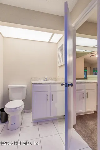 a bathroom with a granite countertop sink a toilet and a mirror
