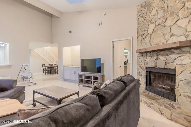 a living room with furniture a flat screen tv and a fireplace