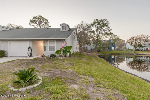 a view of a house with a yard and a lake view