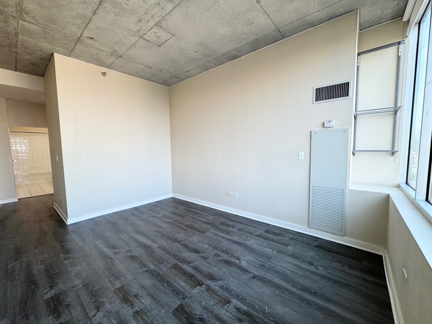 1720 South Michigan Avenue, Unit 1401 Chicago, IL 60616 - Photo 11 of 13 a view of an empty room with wooden floor and a window