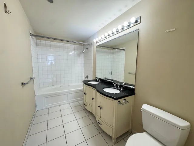 a bathroom with a sink a toilet a mirror and bathtub